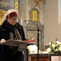 Auf die Bitte von Kanonikus Trstenjak erläutert Margret Hofmann (bei der Predigt) das Altarbild.